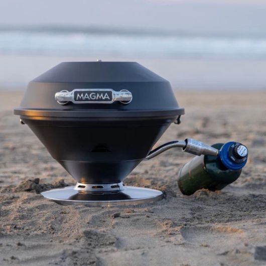 Barbecue portable rond Magma Beach Fire Graphite | Barbecue au gaz pour van et camping-car | Vue lifestyle sur la plage