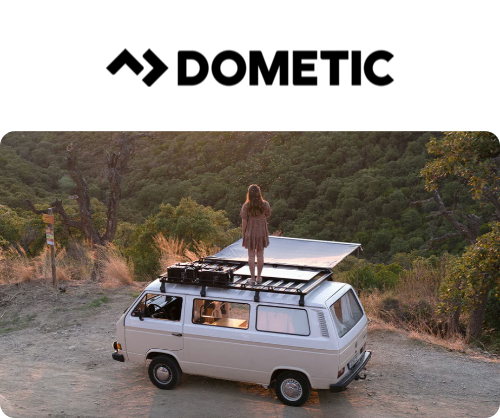 Photo d'un van avec une personne debout sur le toit et logo de la marque DOMETIC au dessus