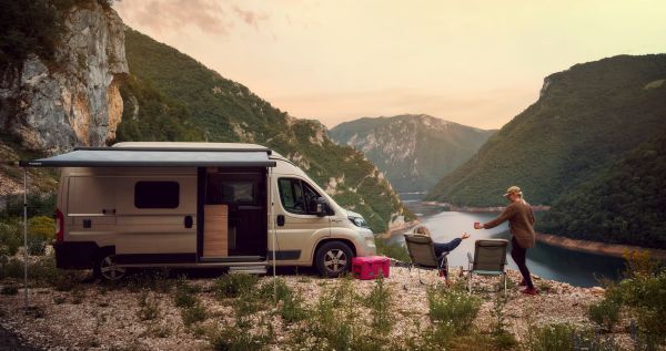 deux personnes qui campent avec leur van devant une belle vue, avec des équipements DOMETIC