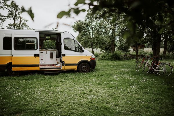 Homme posant devant son camping car