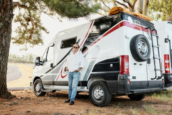 Homme posant devant son camping car